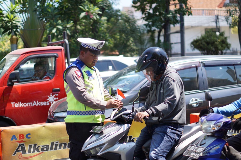 Sambut HUT RI ke-78, Polrestabes Surabaya Berbagi Bendera Merah Putih ke Pengguna Jalan