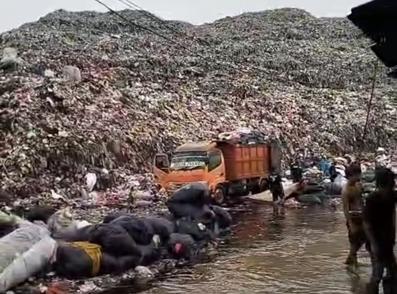 Truk sampah yang masuk melalui jalur Ilegal dari pagar TPA Sumur Batu yang dirobohkan. (Foto: HNN)