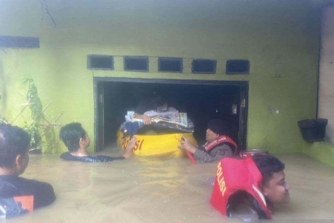 Jajaran Polda Metro Jaya membantu mengevakuasi korban banjir di Kebon Pala, Jaktim. (Foto: Antara)